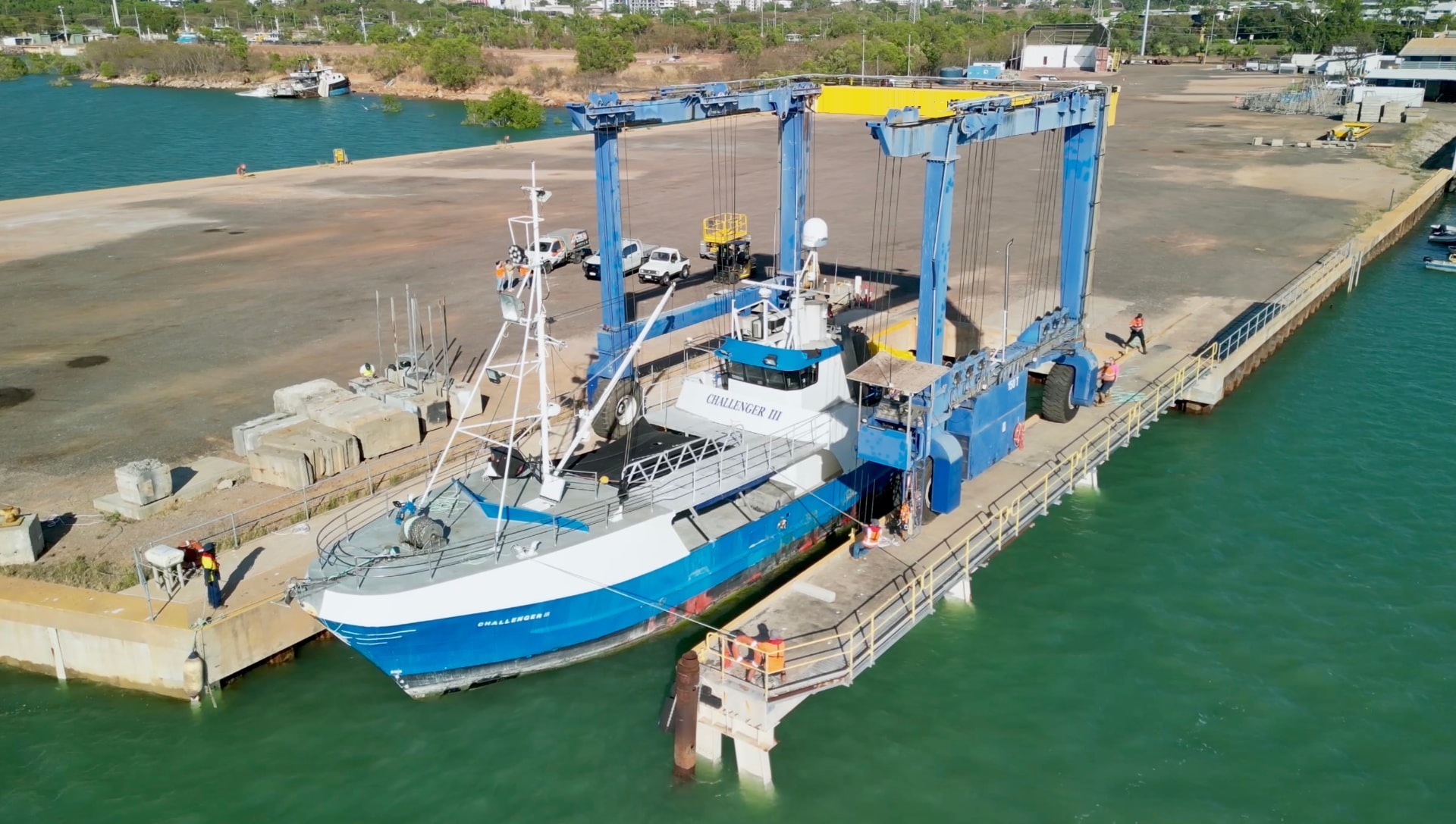 Marine travel lift on the wharf apron of a tropical hardstand facility at sunset